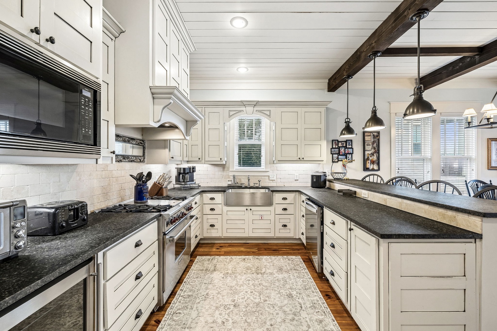 Step into your bright, farmhouse-style kitchen where rustic beams and modern appliances blend seamlessly. You'll love preparing meals on the spacious island while natural light streams through the windows.