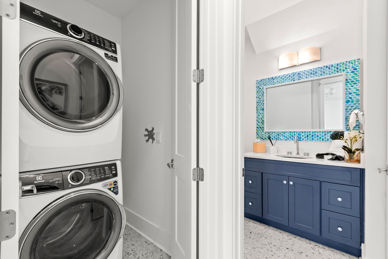Your laundry stays fresh and simple with a stacked washer and dryer tucked right inside. Just steps away, a coastal-inspired vanity with vibrant tile brings color and charm to your daily routine.