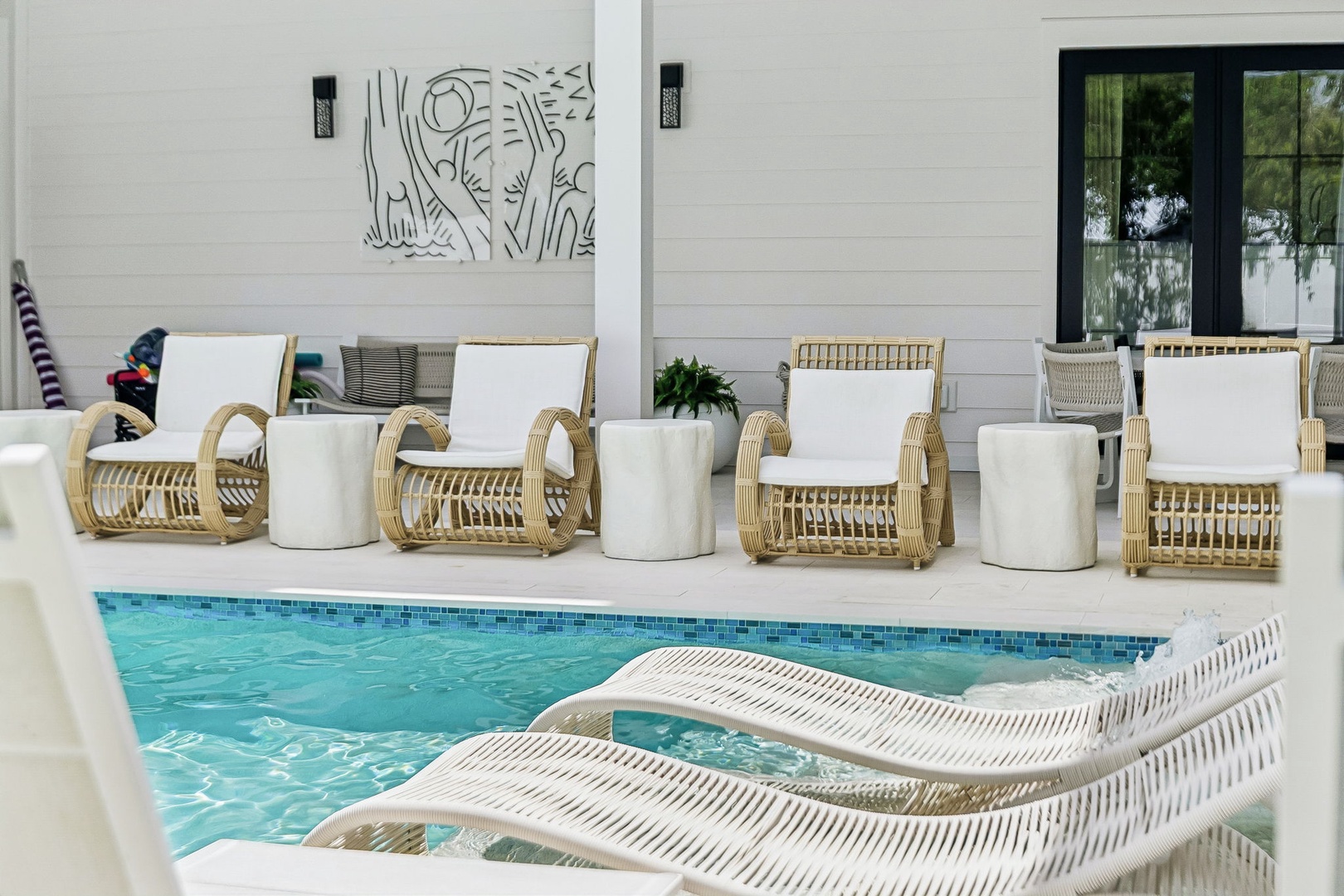 Settle into one of the poolside loungers and let the gentle breeze drift over you. The inviting water and stylish coastal furnishings create your perfect spot to unwind and soak up the sun.