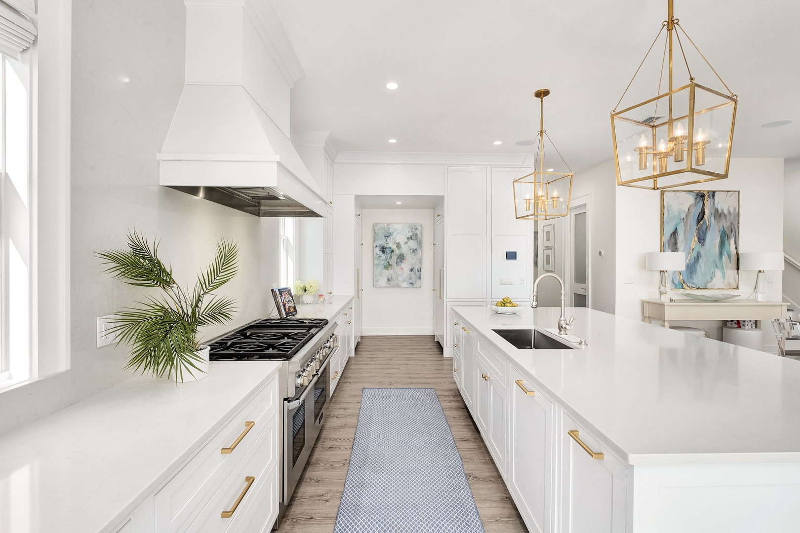 You'll love preparing meals in this bright, beautifully designed kitchen with sleek countertops, modern appliances, and elegant gold fixtures that make cooking feel effortless and inspiring.