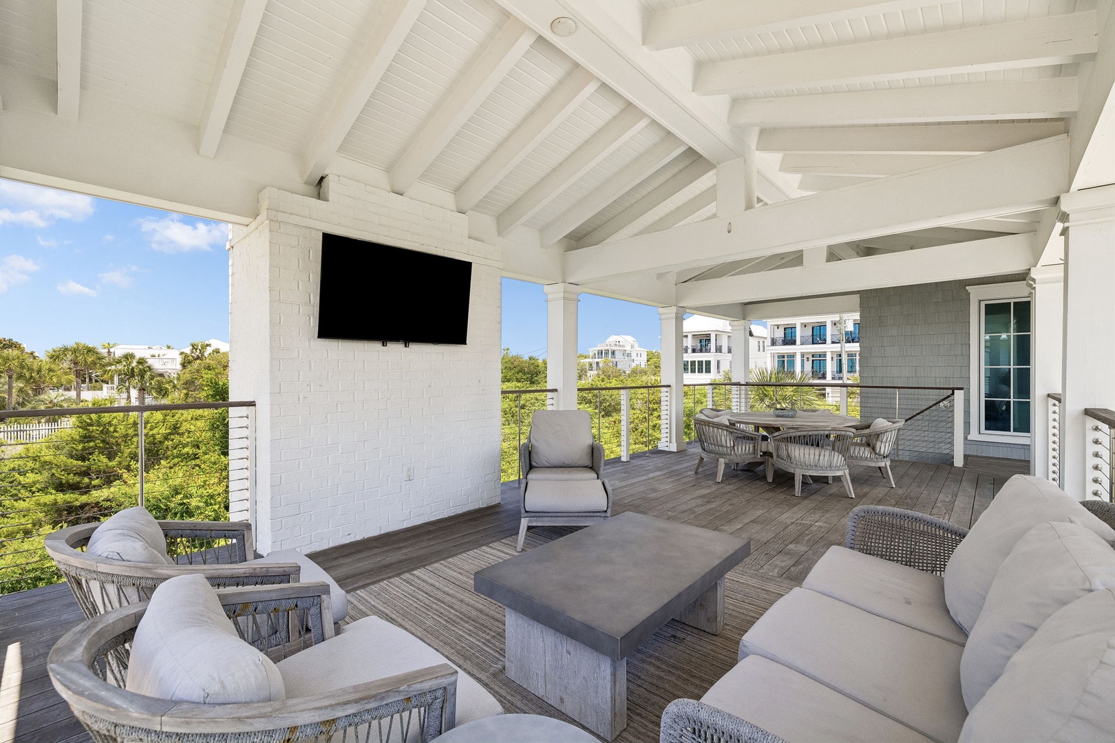 Unwind on your spacious covered terrace with vaulted ceilings, plush seating, and a wall-mounted TV. Perfect for relaxing while enjoying the lush surrounding views and coastal breeze.