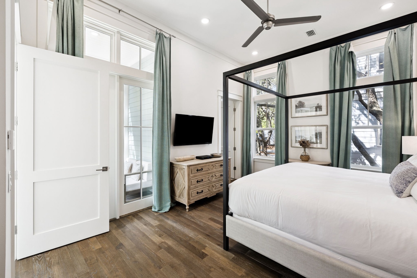 Relax in your elegant canopy bed while enjoying the ceiling fan's gentle breeze and modern amenities like the flat-screen TV.