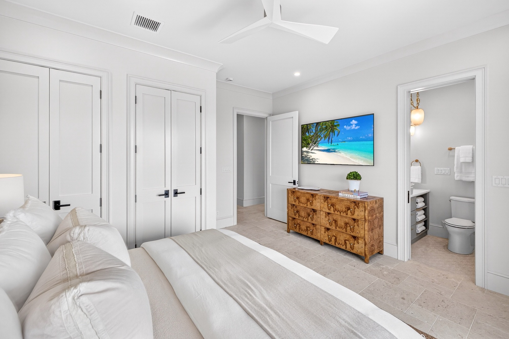 Unwind in your serene master suite with crisp white linens, modern amenities, and an ensuite bathroom for ultimate comfort.