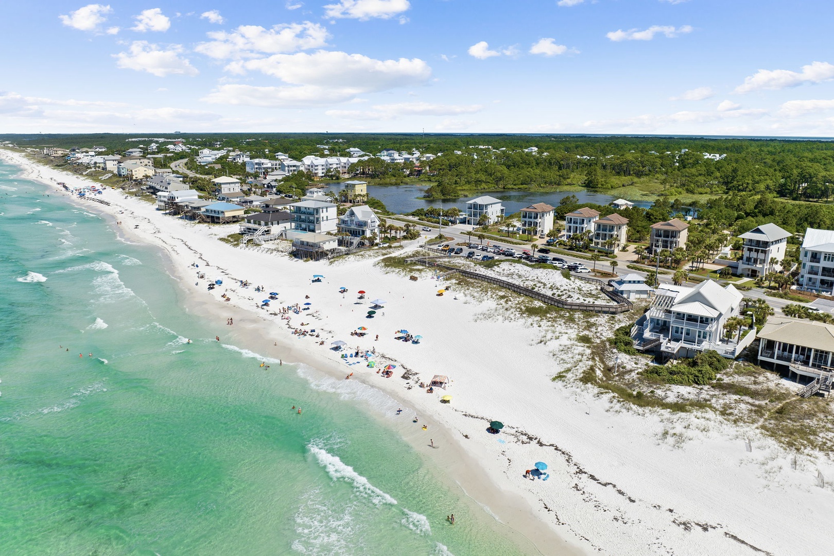 Stunning aerial view of pristine white sand beaches and emerald waters along this coastal community.
