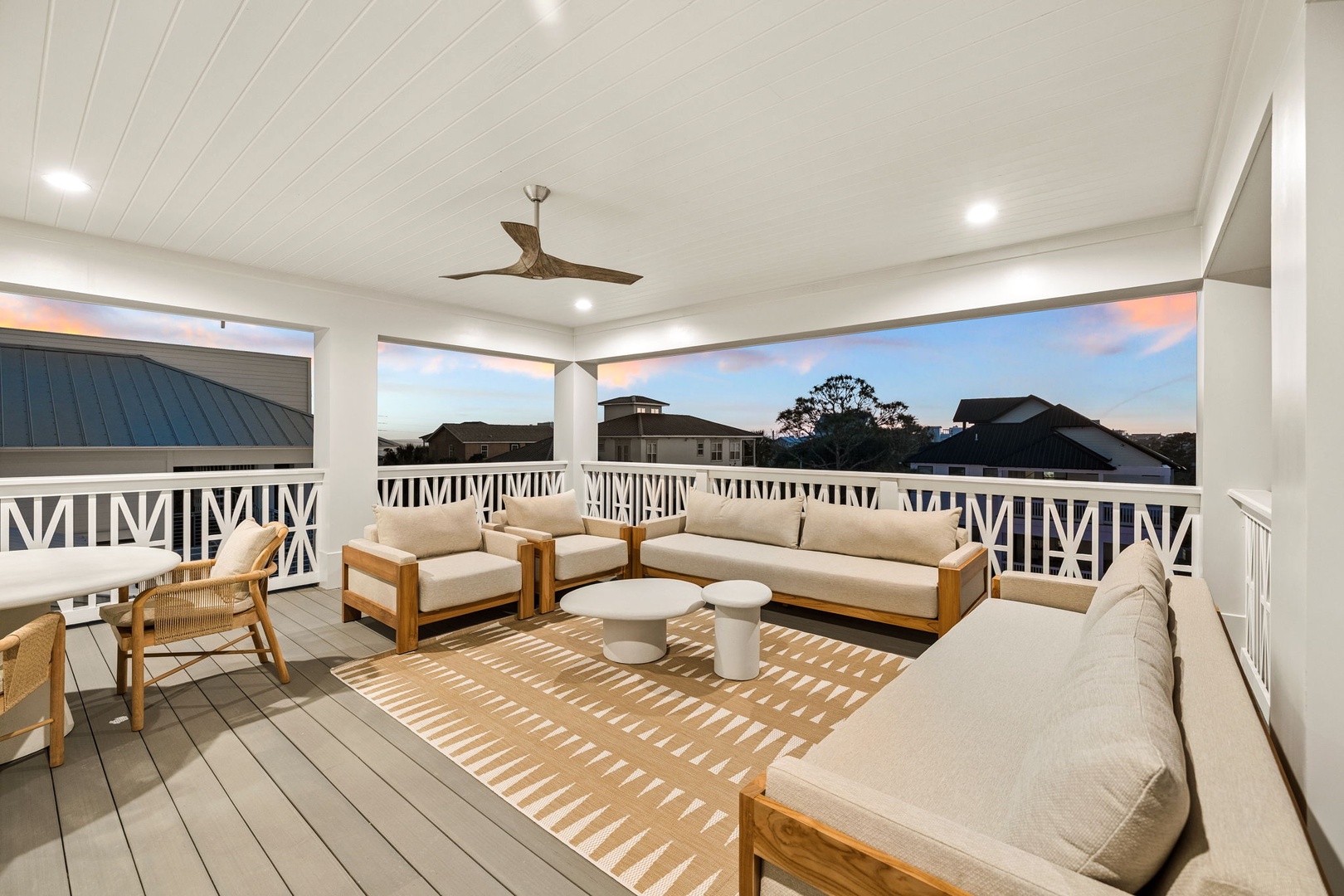 Unwind on your private covered terrace with panoramic neighborhood views, comfortable seating, and gentle ceiling fan breezes for perfect evening relaxation.