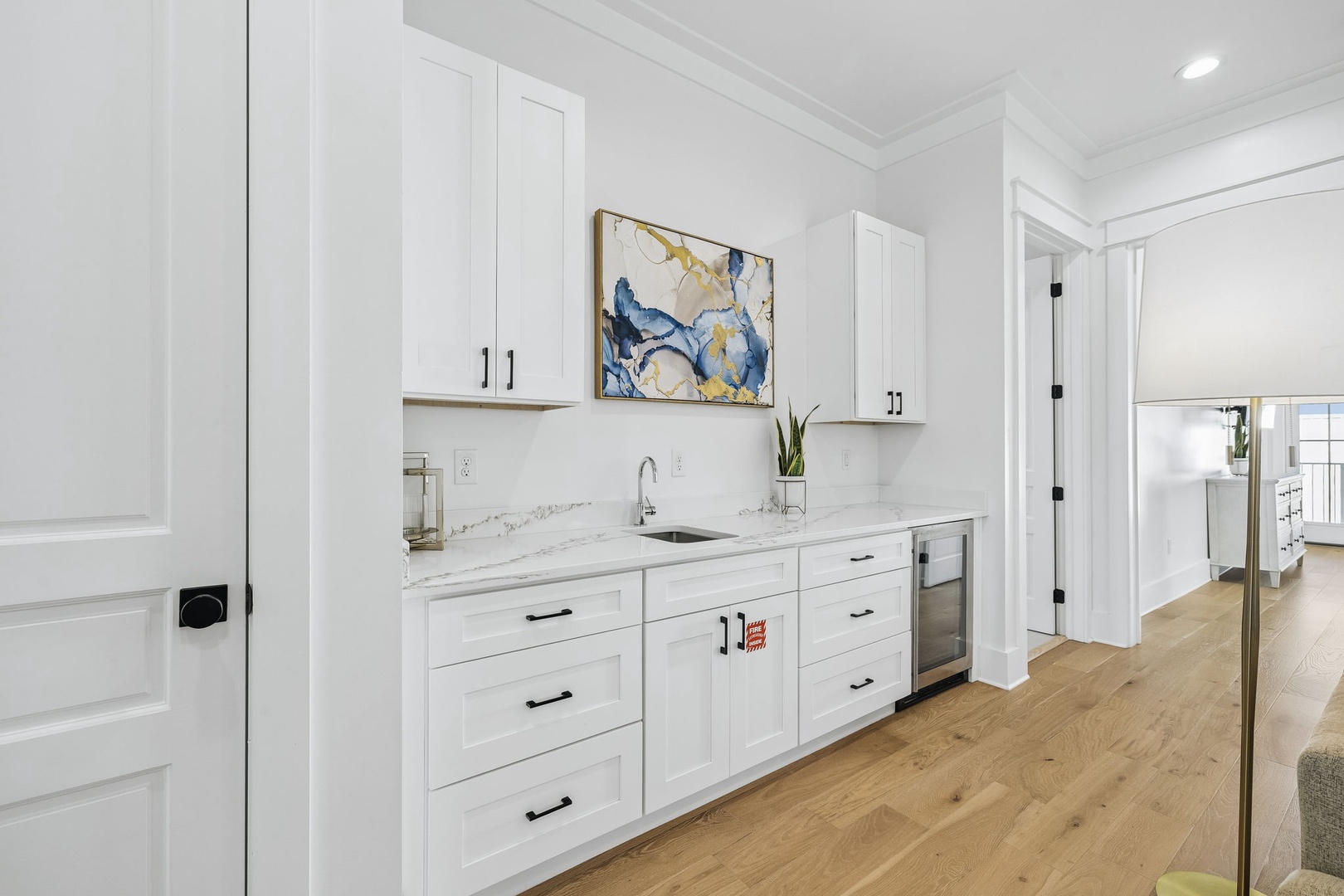 Your sleek kitchenette awaits with marble counters, stainless appliances, and crisp white cabinetry—perfect for easy meal prep or morning coffee in style.