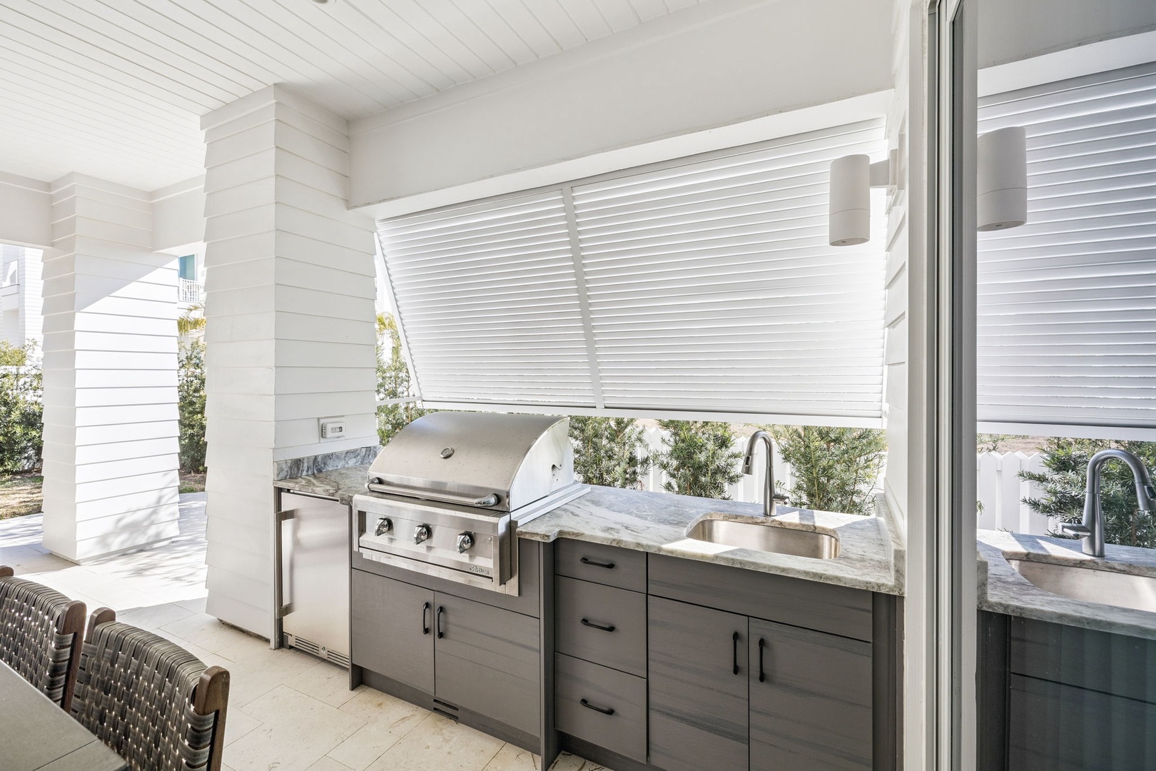 Your outdoor kitchen awaits with premium grill and marble counters, perfect for entertaining under covered comfort.