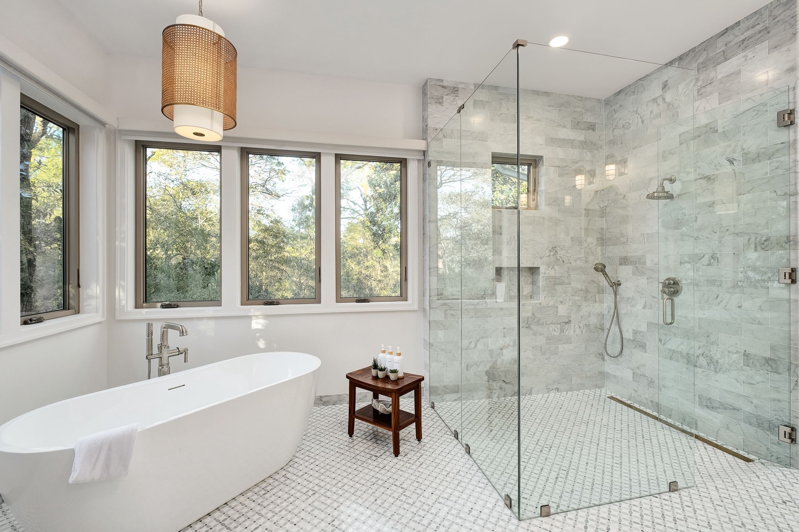Unwind in your luxurious marble bathroom with soaking tub and spacious glass shower, while natural light streams through windows.