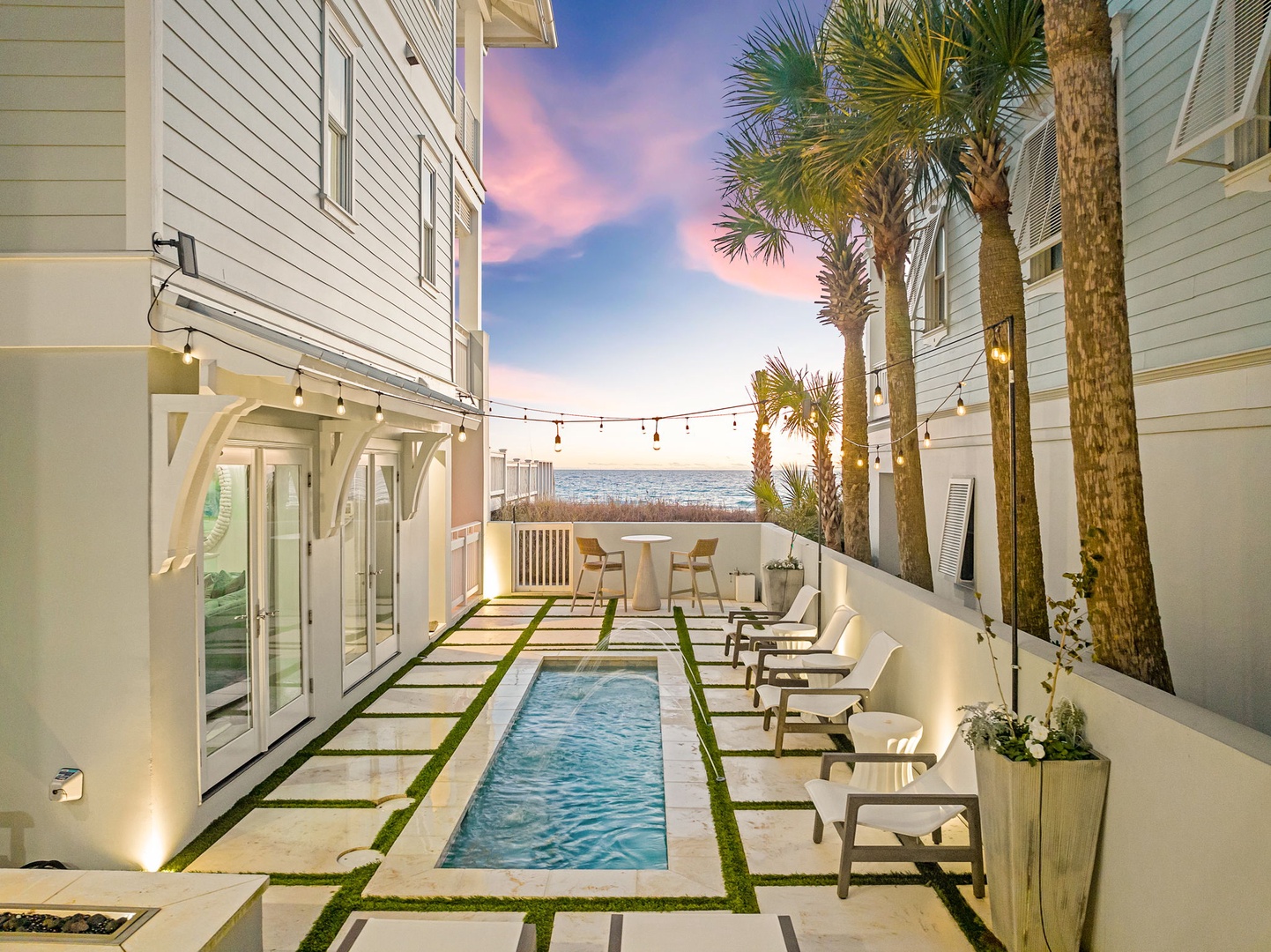 A serene coastal retreat featuring a private pool courtyard framed by swaying palms and ocean breezes, where twilight skies paint the perfect backdrop for unwinding in your secluded oasis.