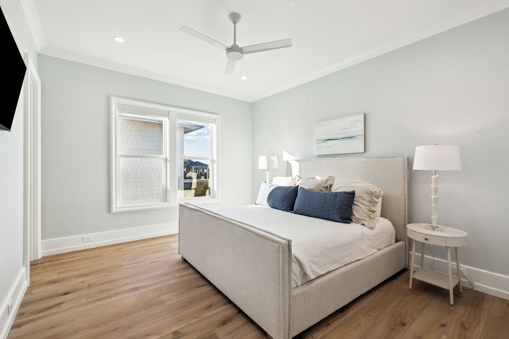 Drift off in your serene bedroom with crisp linens, gentle ceiling fan, and calming coastal touches for perfect restful nights.