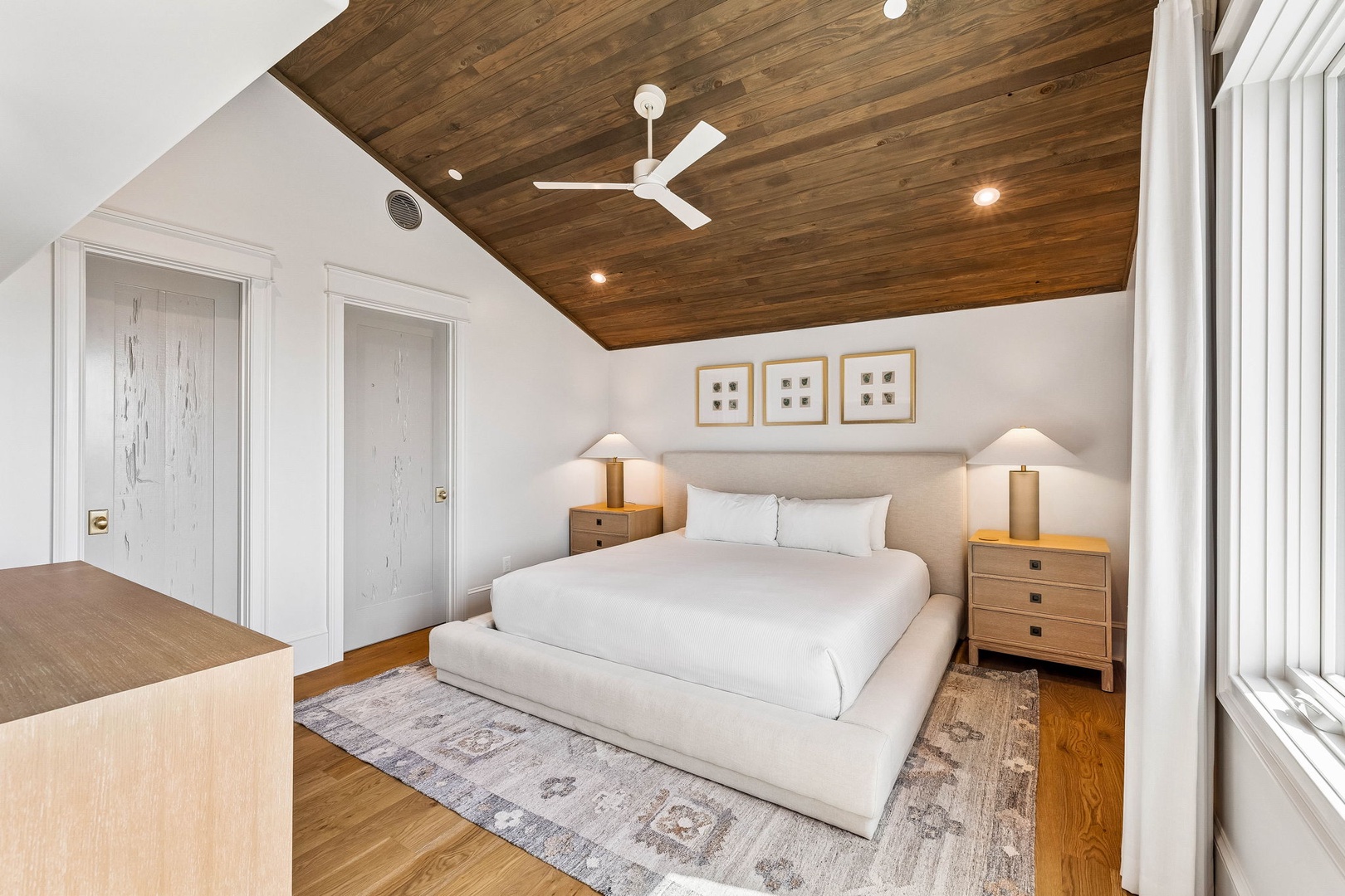 Sink into the plush king bed beneath the striking wood-paneled ceiling, where soft lighting and warm textures create your perfect retreat.