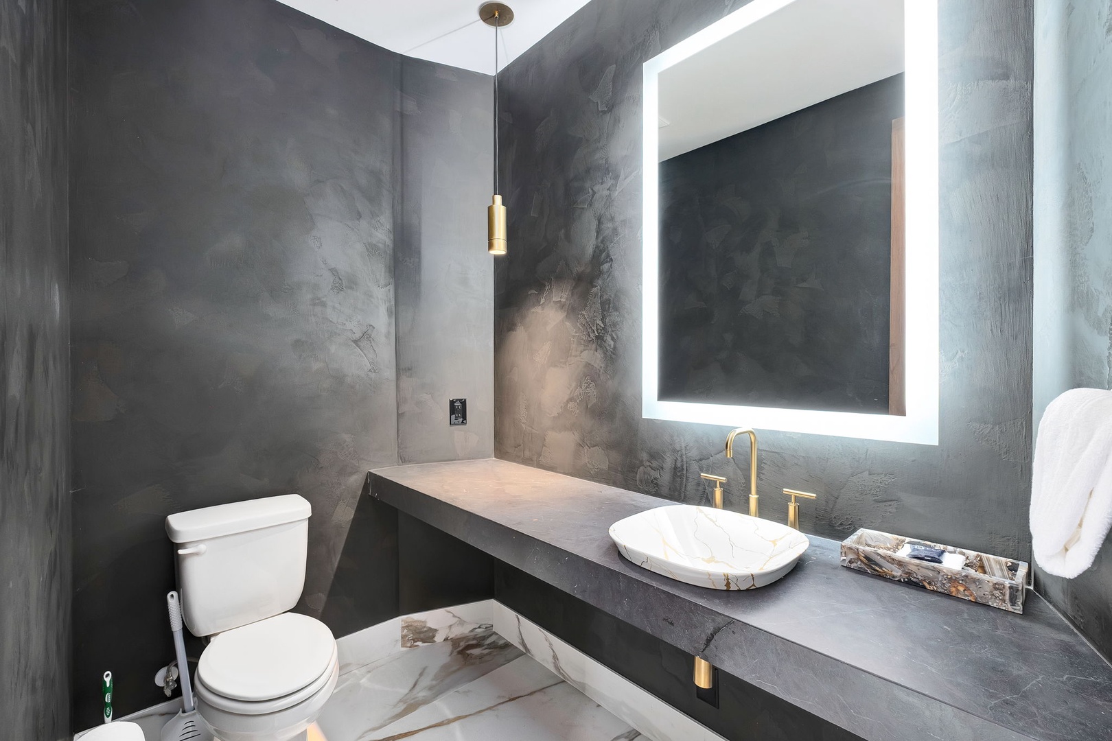 Sleek industrial design meets modern elegance in your private bathroom, where textured charcoal walls and warm brass fixtures create a sophisticated spa-like retreat.