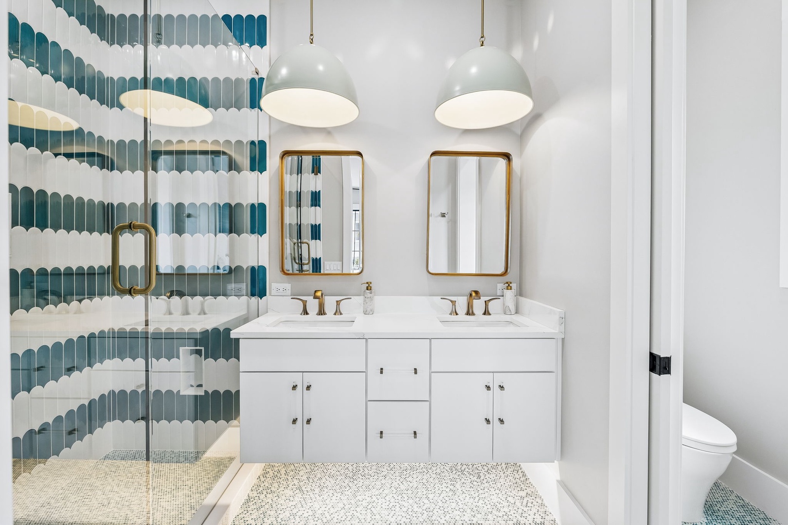 Refresh in your modern, spa-inspired bathroom with dual vanities, ocean-hued tile work, and a sleek glass-enclosed shower designed for your comfort.