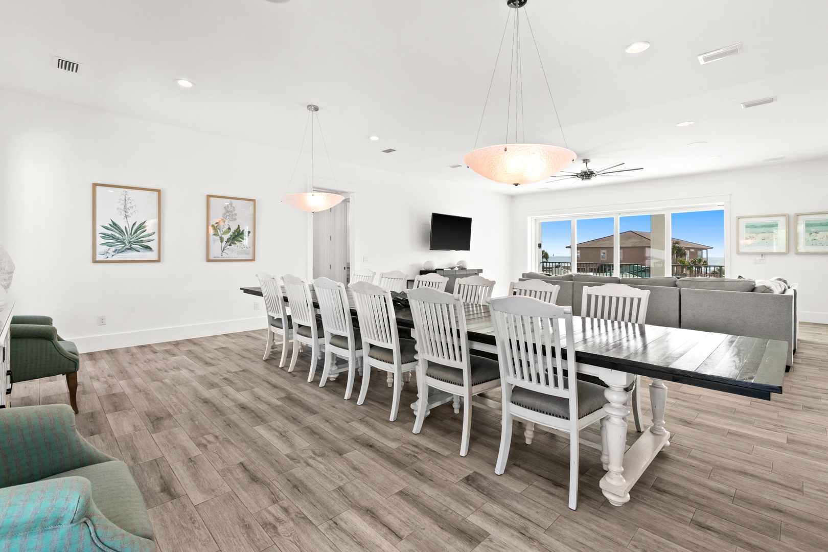 Gather your whole crew around this elegant farmhouse-style dining table, where coastal-inspired decor and soft lighting create the perfect atmosphere for memorable meals together.