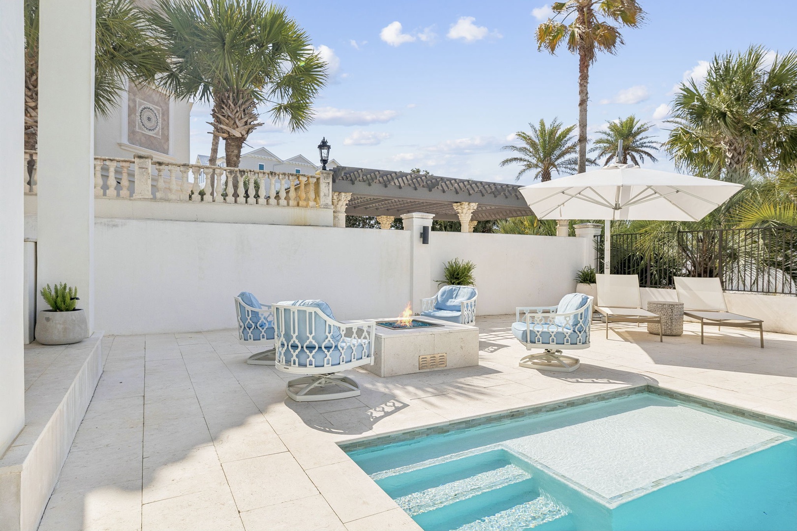 Relax in your private pool paradise surrounded by palm trees and comfortable seating.