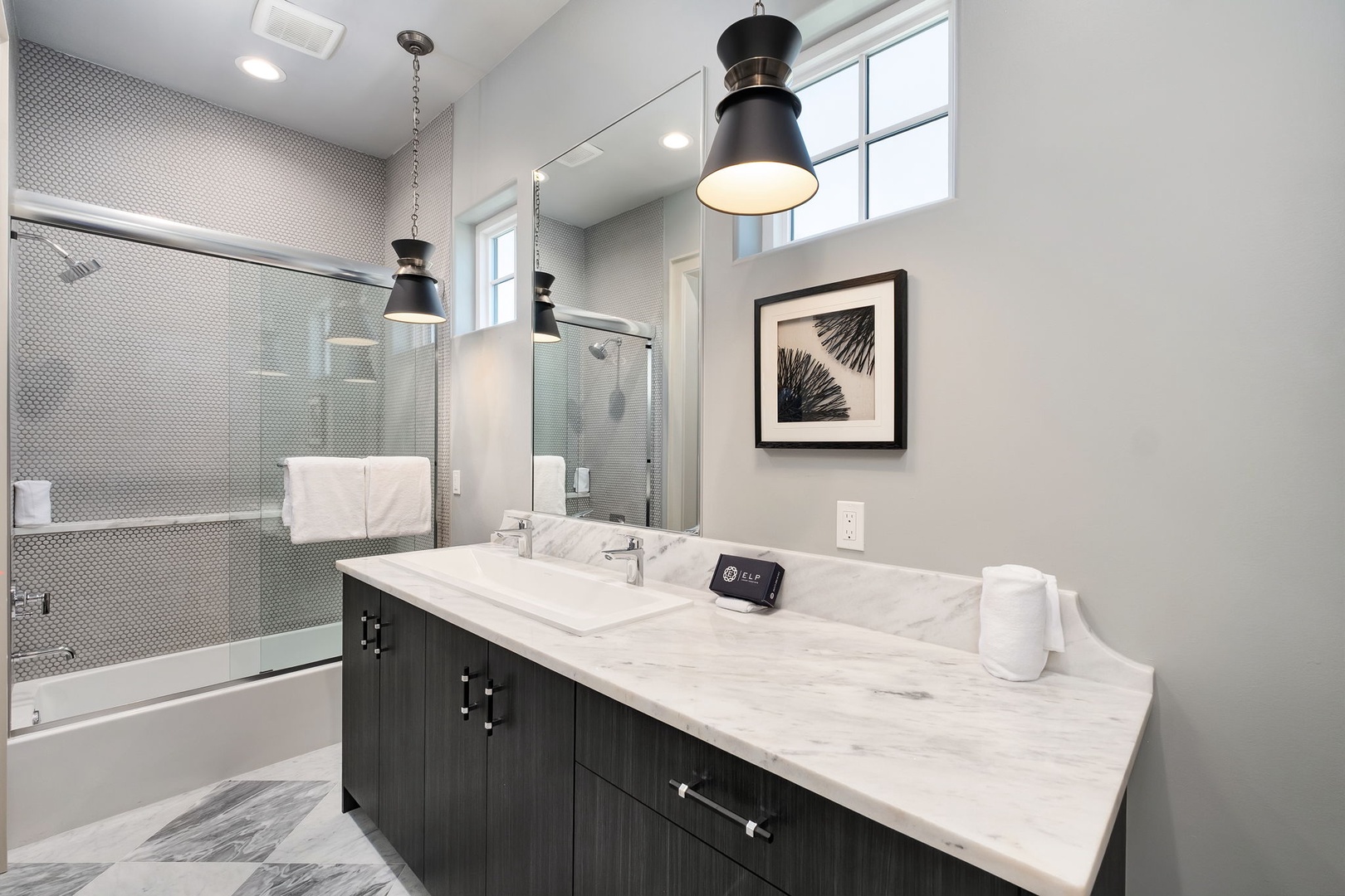 Your modern bathroom features marble counters, stylish pendant lights, and a luxurious glass-enclosed tub for ultimate relaxation.