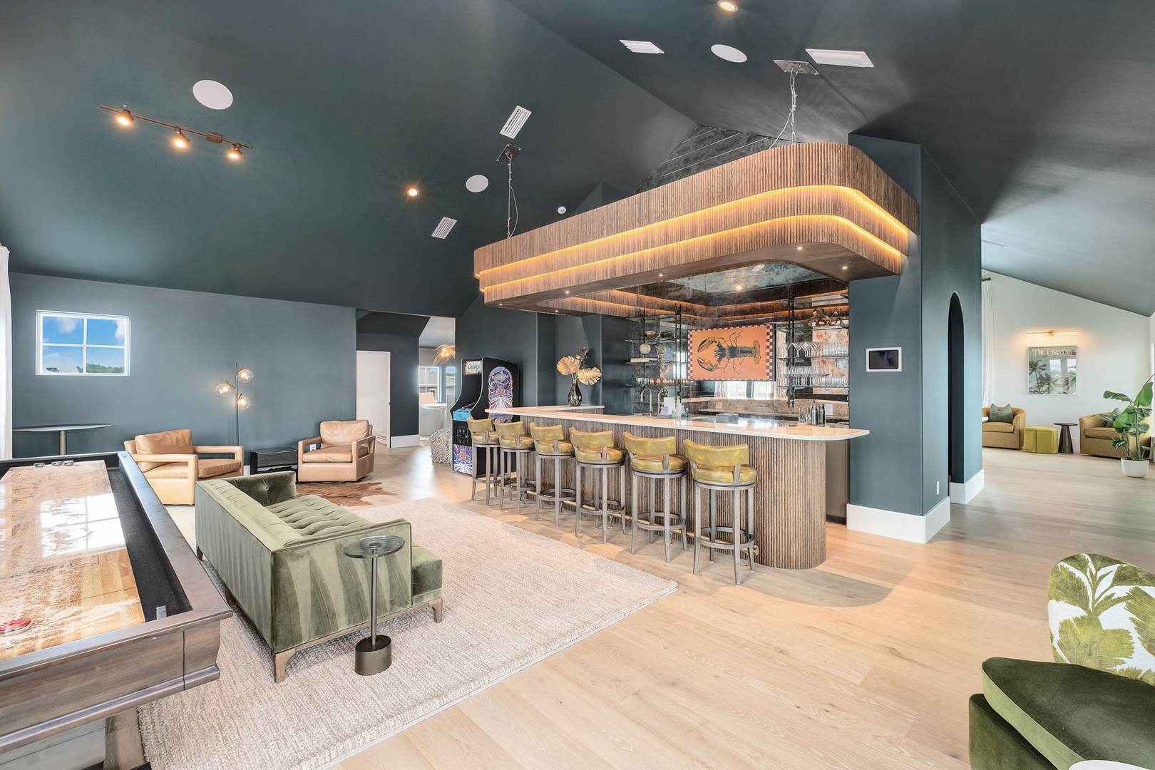 Stylish shared lounge and bar area featuring modern decor, plush seating, and a stunning statement light fixture—perfect for gathering and unwinding with fellow travelers.