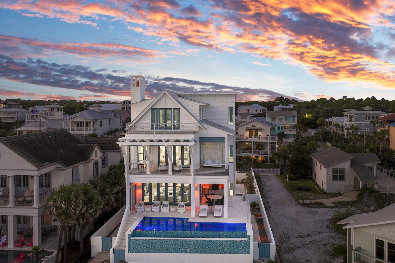 A stunning coastal property set against a brilliant sunset, featuring a private pool and contemporary architectural design in a peaceful beachside neighborhood.