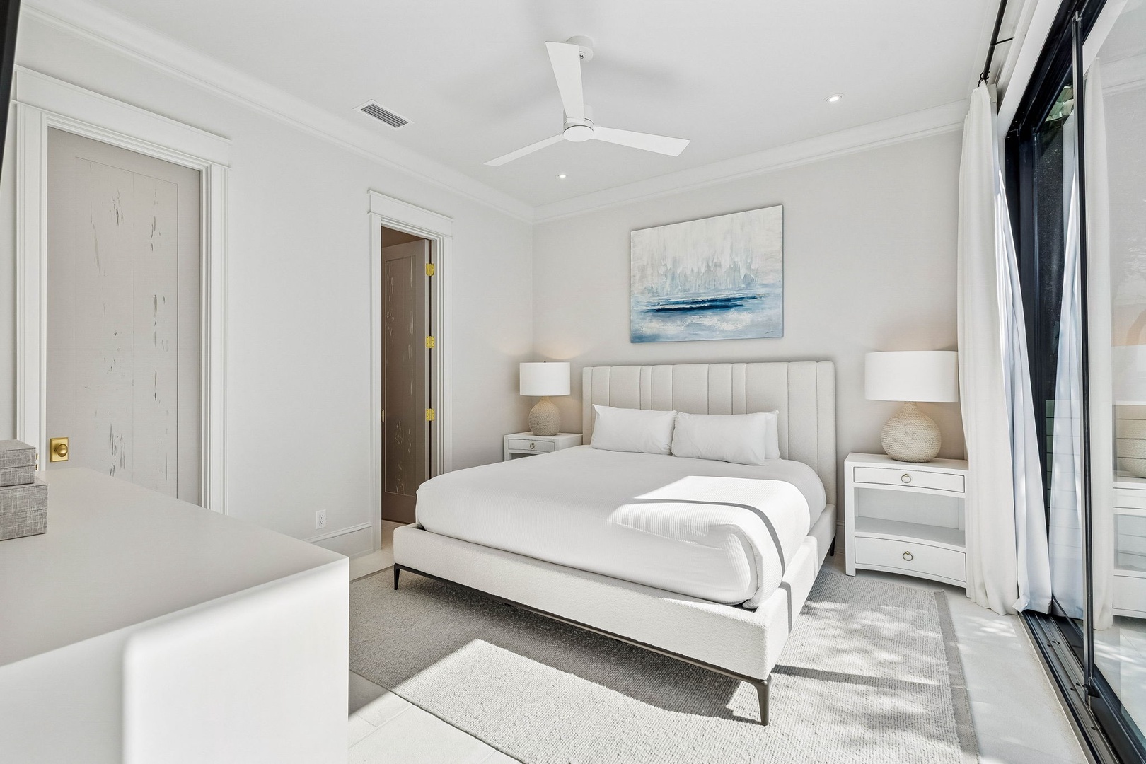 Sink into the plush linens and coastal charm of this serene bedroom, where crisp white tones and soft textures invite your most restful night's sleep.