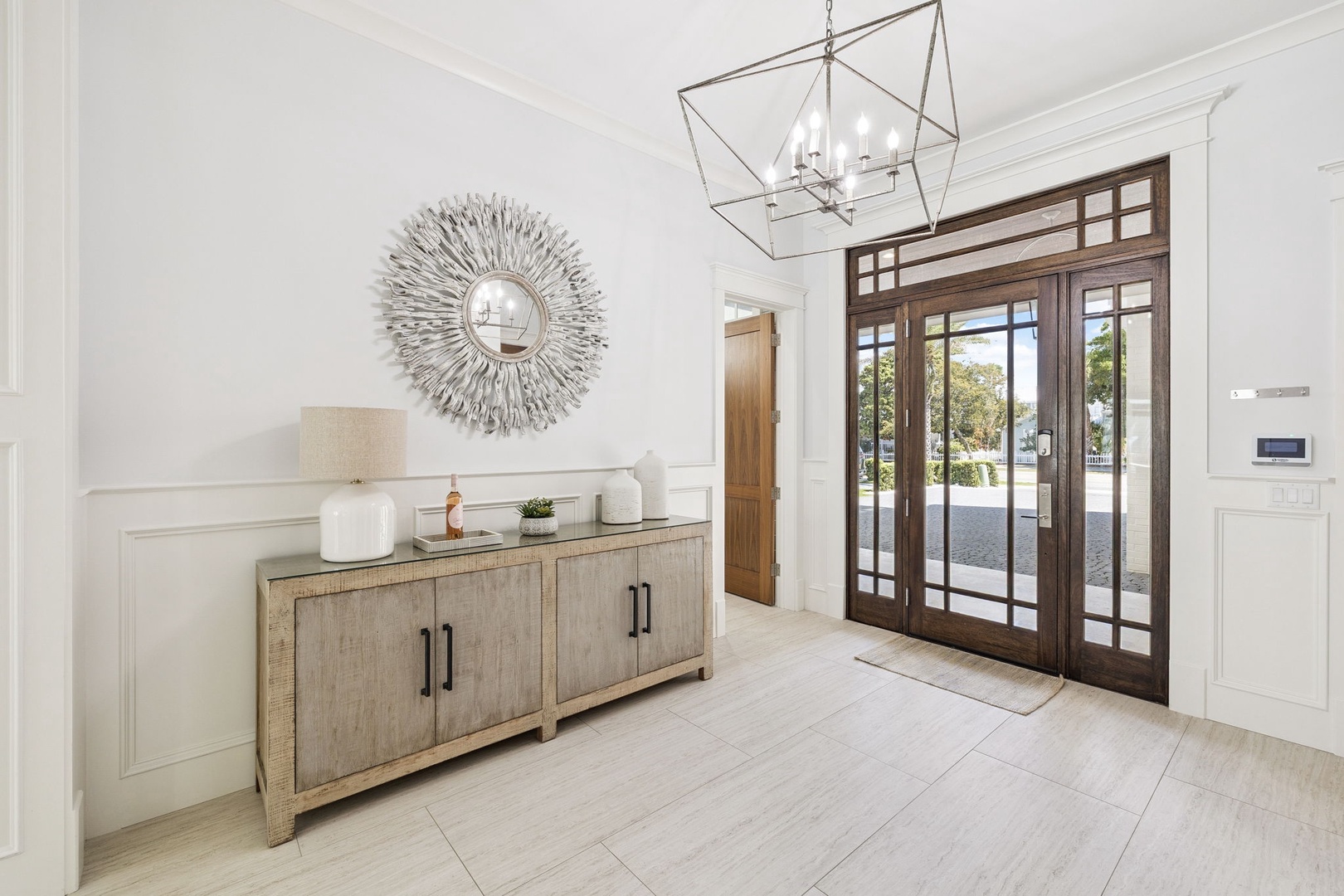 Step into your elegant entryway where a stunning sunburst mirror and modern pendant light create the perfect first impression.