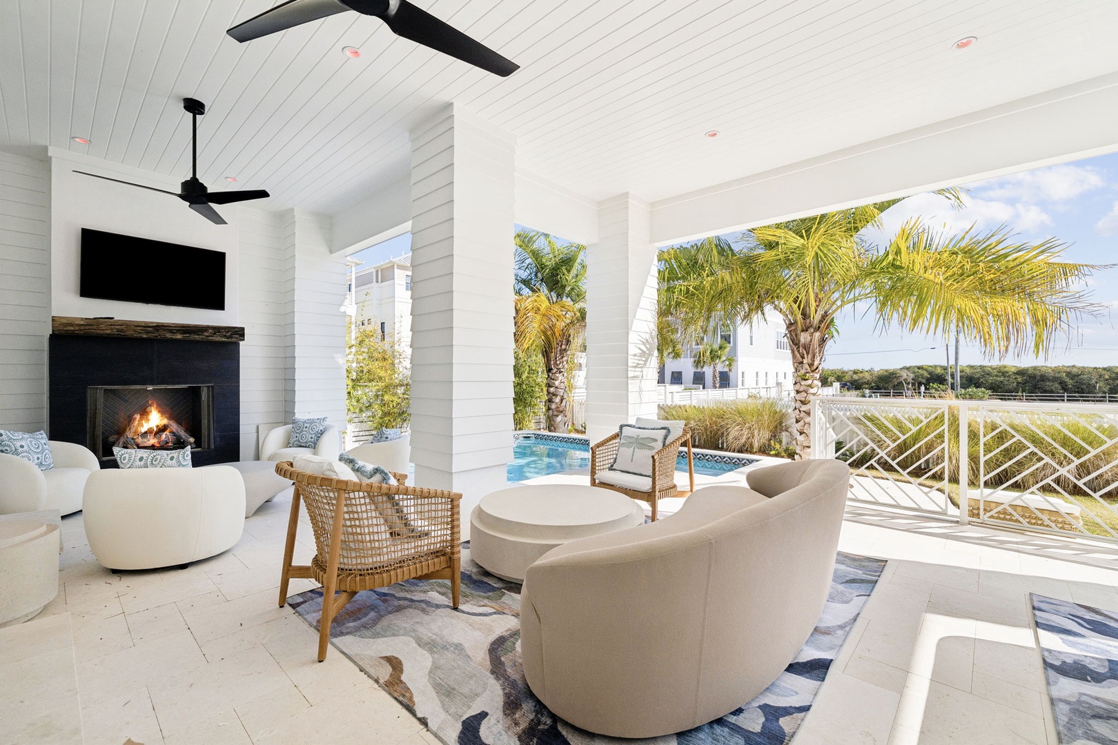 Unwind in this elegant covered terrace where your cozy fireplace meets tropical breezes and stunning pool views.