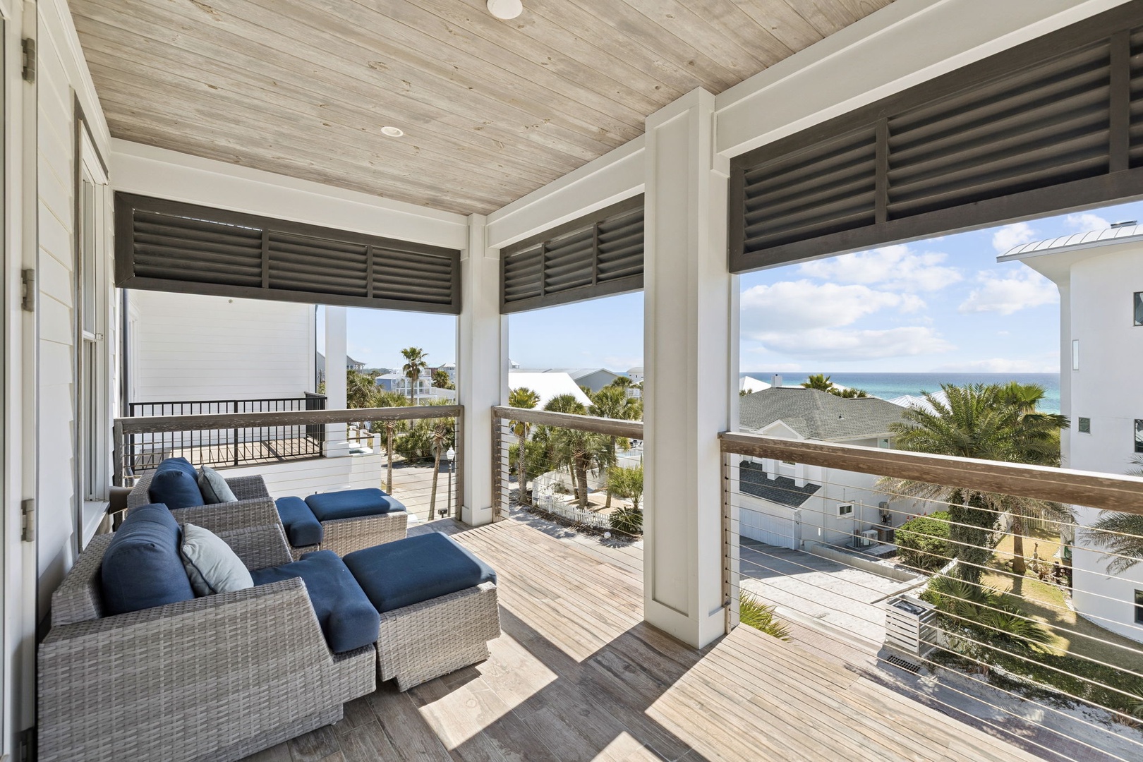 Unwind in your covered terrace with stunning sea views, where blue-cushioned seating invites you to relax as ocean breezes drift through.