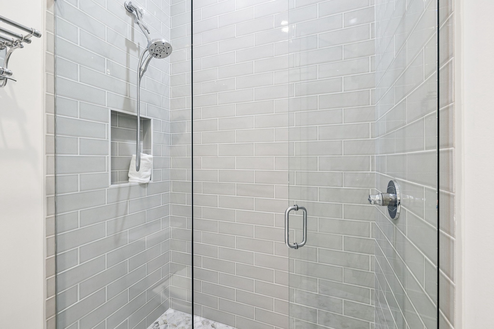 Step into your spa-like shower with elegant subway tiles, rainfall showerhead, and convenient built-in shelf for your essentials.