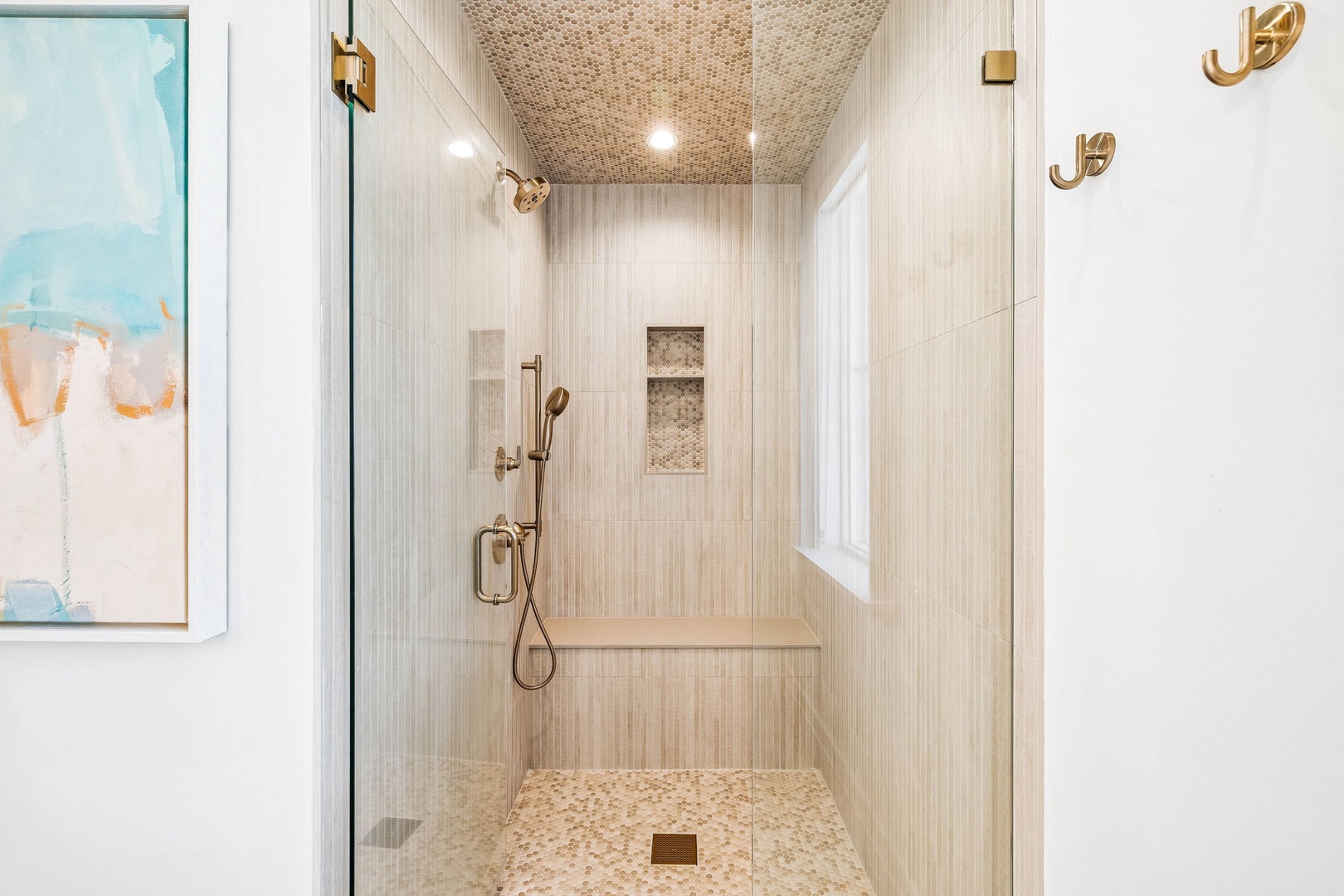 Step into your beautifully tiled walk-in shower, where elegant brass fixtures and a textured ceiling create a spa-like retreat. The built-in bench and niche offer both comfort and convenience.