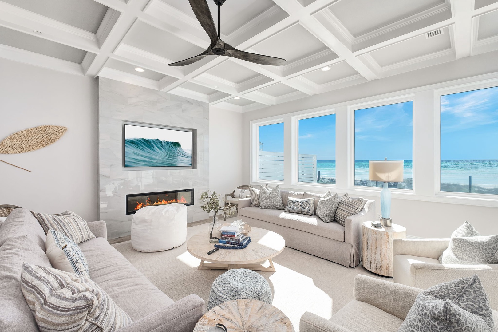 Sink into plush coastal comfort while watching waves through floor-to-ceiling windows in your stunning oceanfront living room.