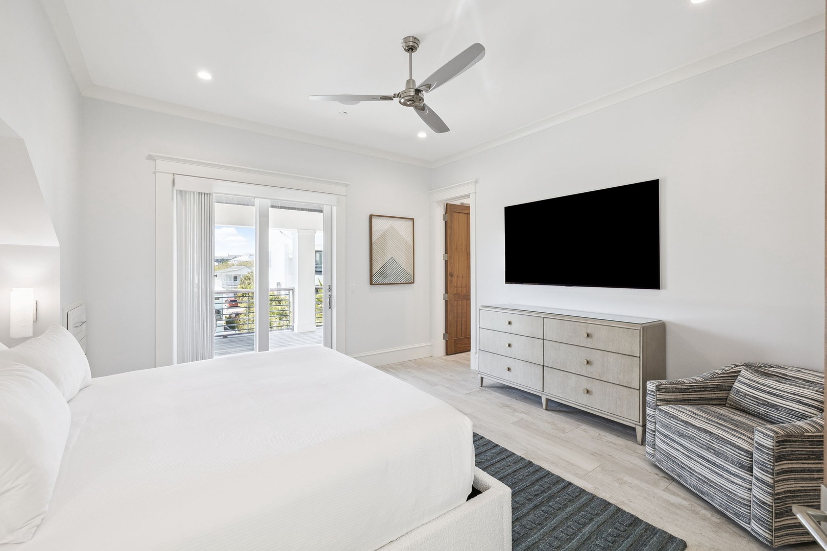 Drift off in your serene master bedroom with crisp linens, gentle ceiling fan, and bright balcony doors opening to peaceful views.