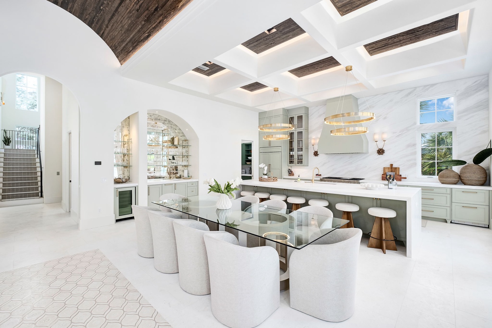 Step into your sunlit culinary sanctuary with soaring coffered ceilings, elegant archways, and a spacious island perfect for gathering and creating memories together.