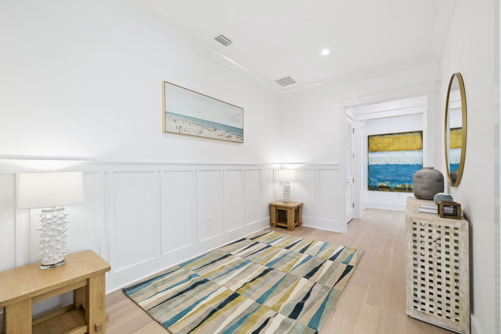 Step into your bright coastal hallway where beach-inspired artwork and warm wood touches create a serene welcome to your retreat.