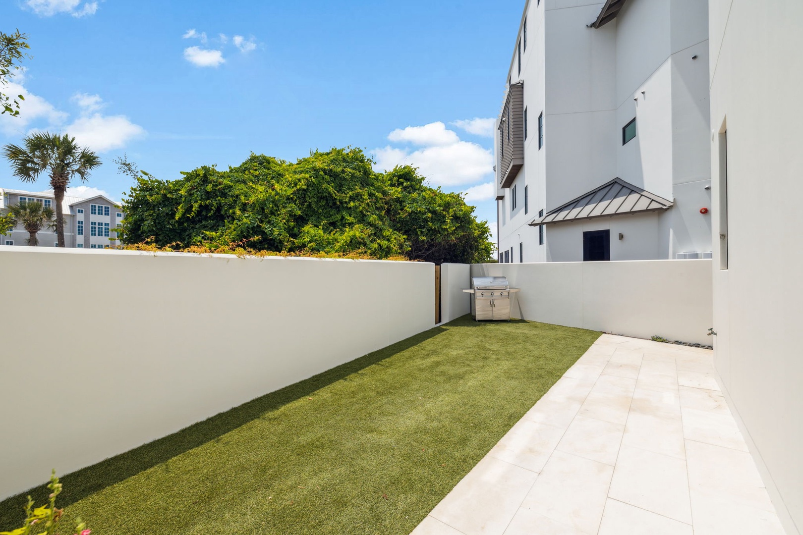 Your private backyard oasis awaits with lush green lawn, shade trees, and a built-in BBQ grill—perfect for sunny afternoons and effortless outdoor entertaining.