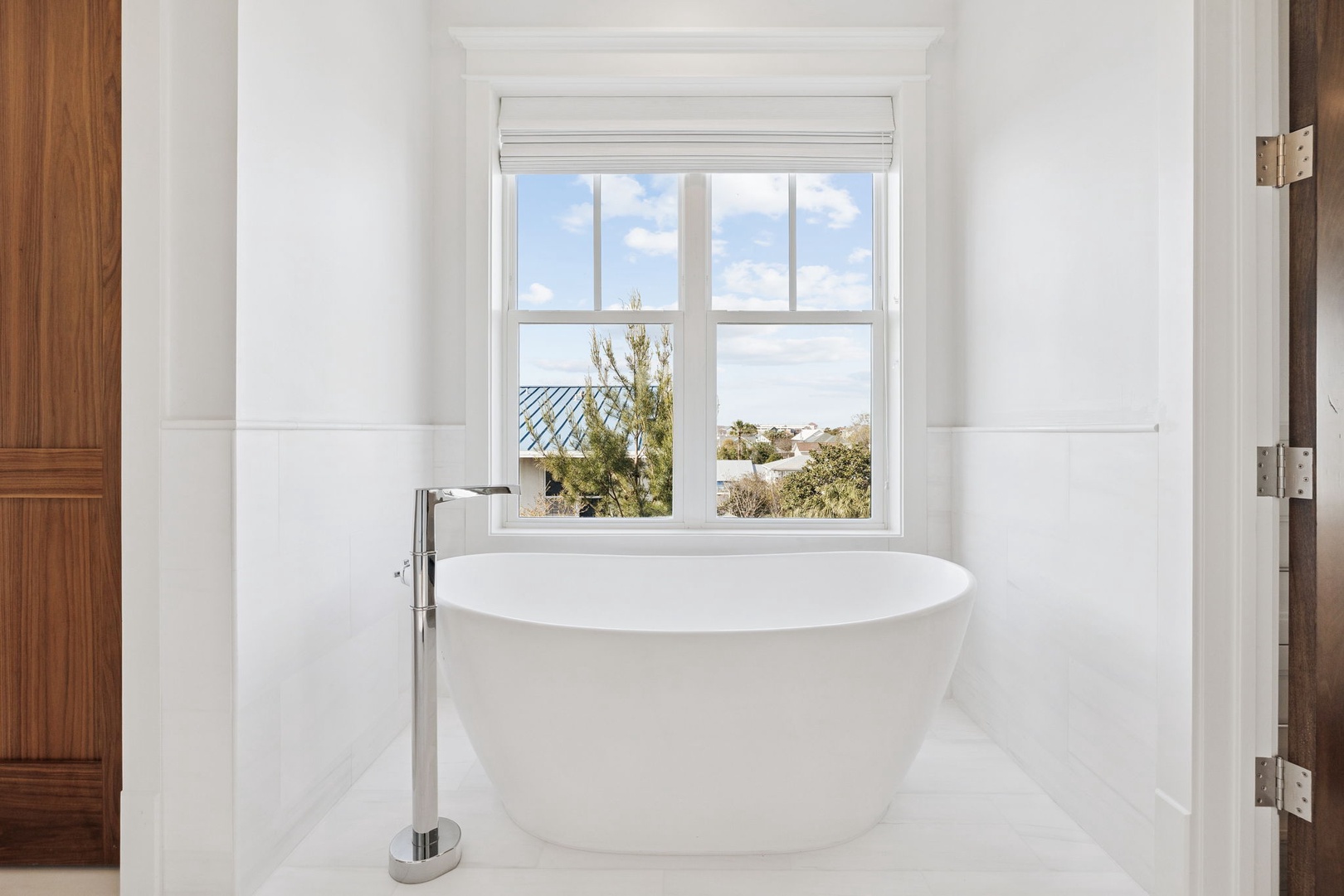 Sink into luxury in your elegant freestanding tub, where marble surrounds and peaceful neighborhood views create your perfect sanctuary.