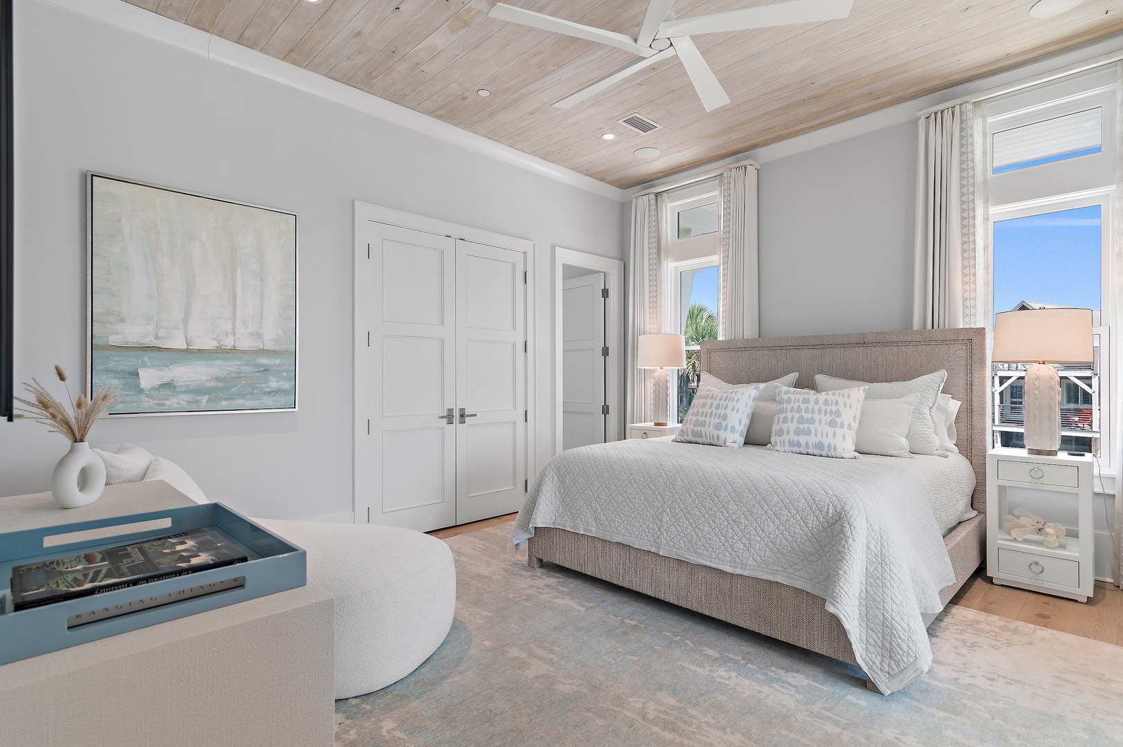 Drift off in this serene bedroom with coastal-inspired tones, soft linens, and a wood-plank ceiling. Your peaceful retreat features a plush upholstered bed and gentle ocean breezes through the windows.