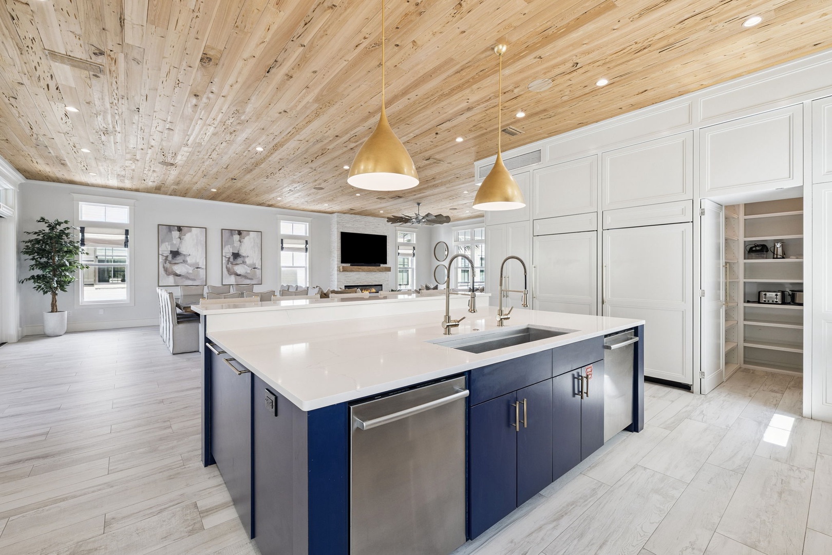 Step into your gourmet kitchen featuring sleek marble countertops, premium appliances, and warm wood ceilings that create the perfect culinary sanctuary.