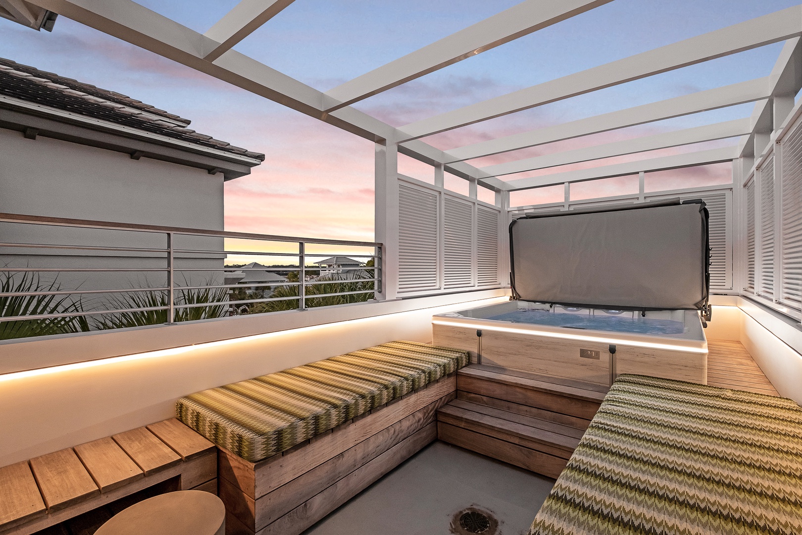 Unwind in your private hot tub as the sky paints pastel hues above, with cozy seating and warm lighting creating the perfect evening sanctuary.