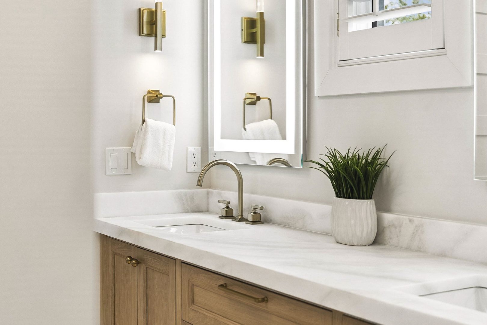 Step into your elegant ensuite featuring polished marble countertops, warm brass fixtures, and soft natural light that creates a serene, spa-like retreat just for you.