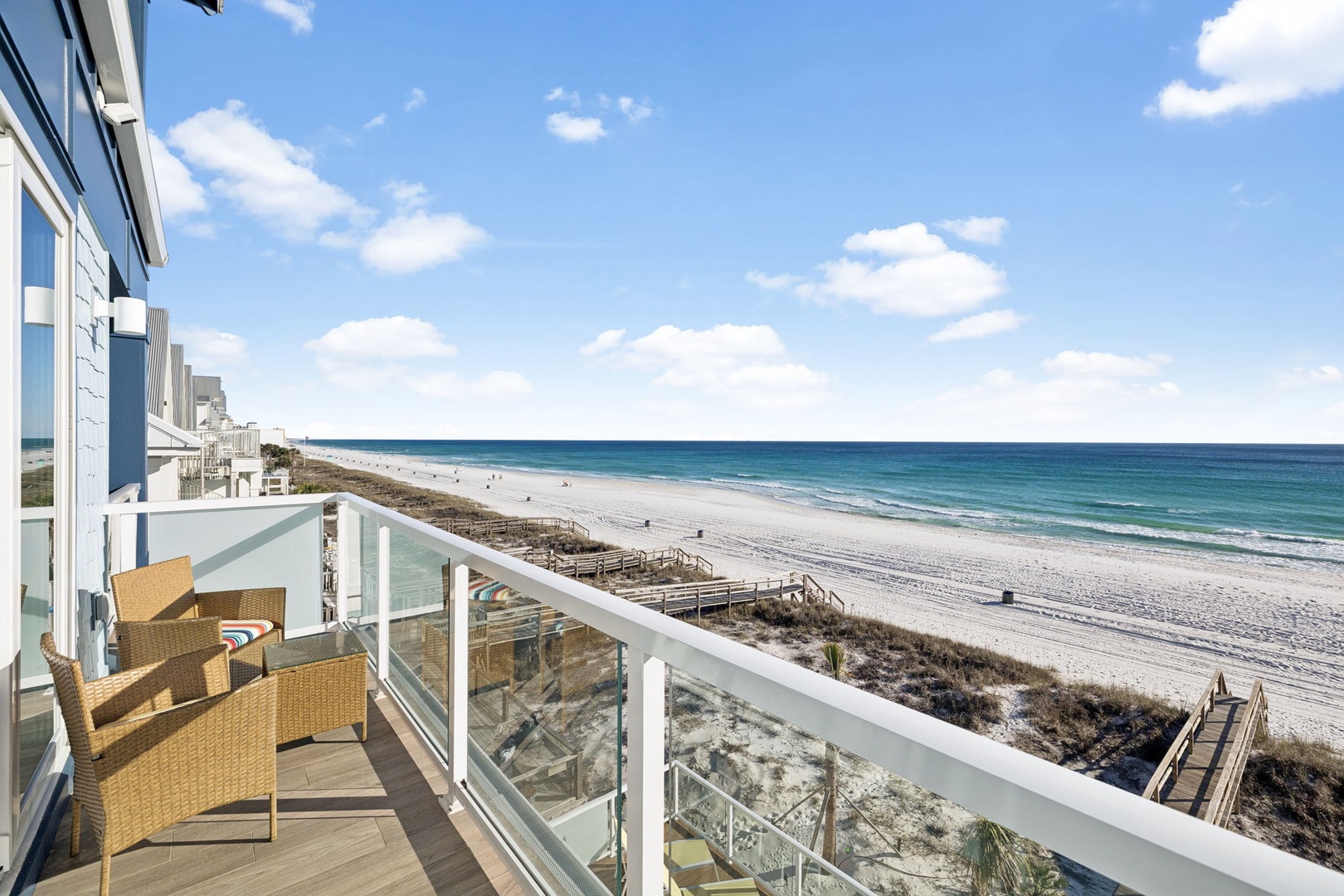 Unwind on your private balcony with stunning ocean views and comfortable seating, where endless beach stretches invite relaxation.