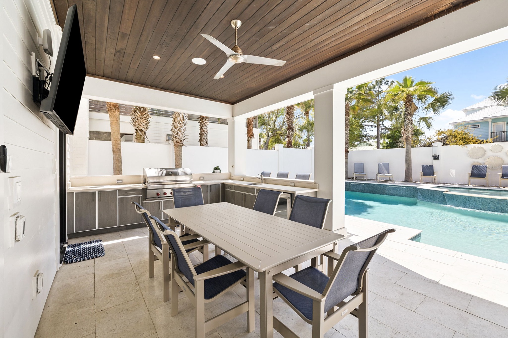 Your covered outdoor kitchen opens to sparkling pool views, perfect for cooking while guests relax nearby.