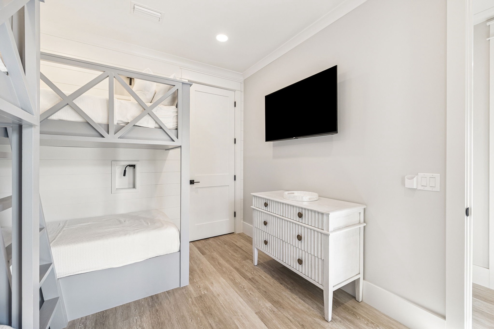 Your cozy bunk room features a flat-screen TV and charming white dresser, perfect for family stays.