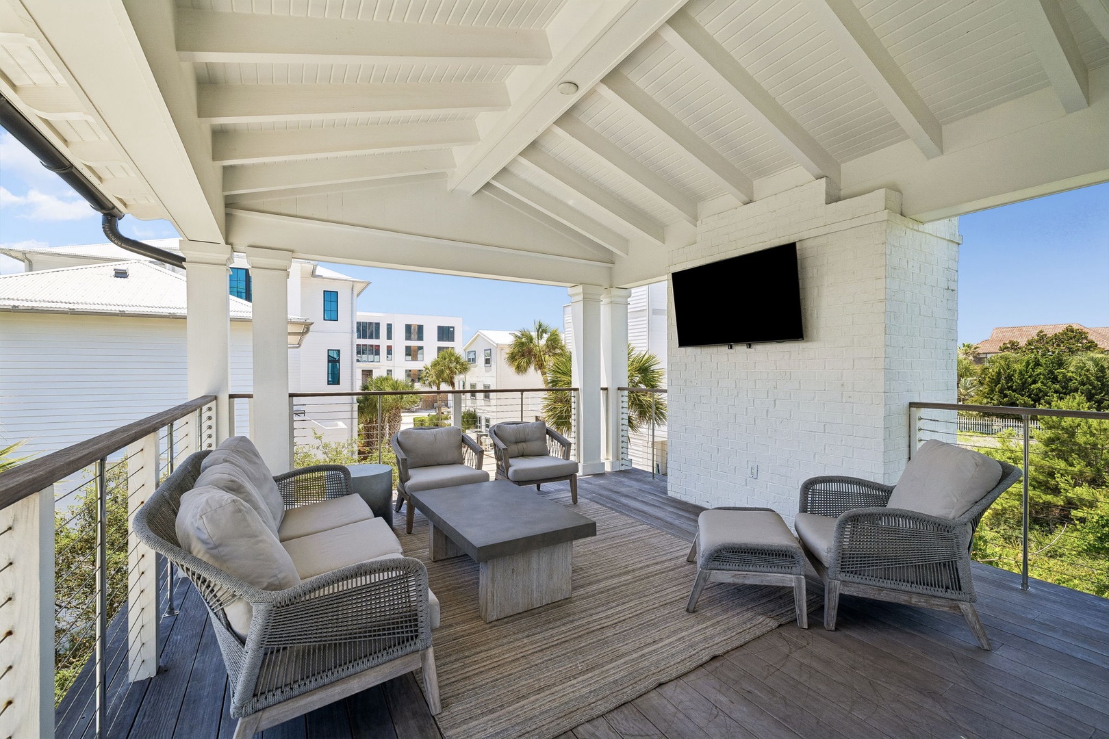 Relax in your private covered balcony with plush seating, a wall-mounted TV, and lush tropical views—the perfect spot to unwind and soak in the coastal breeze.