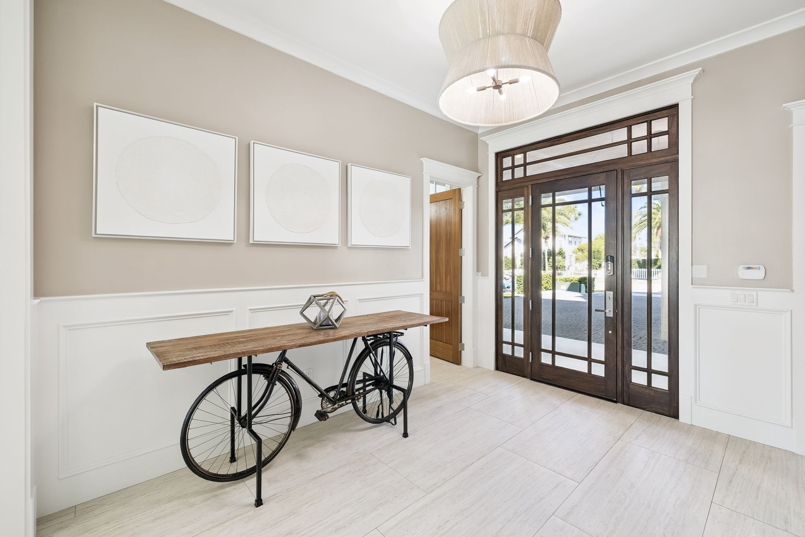 Step into your stylish foyer where elegant design meets coastal charm, featuring warm wood tones and sophisticated lighting.