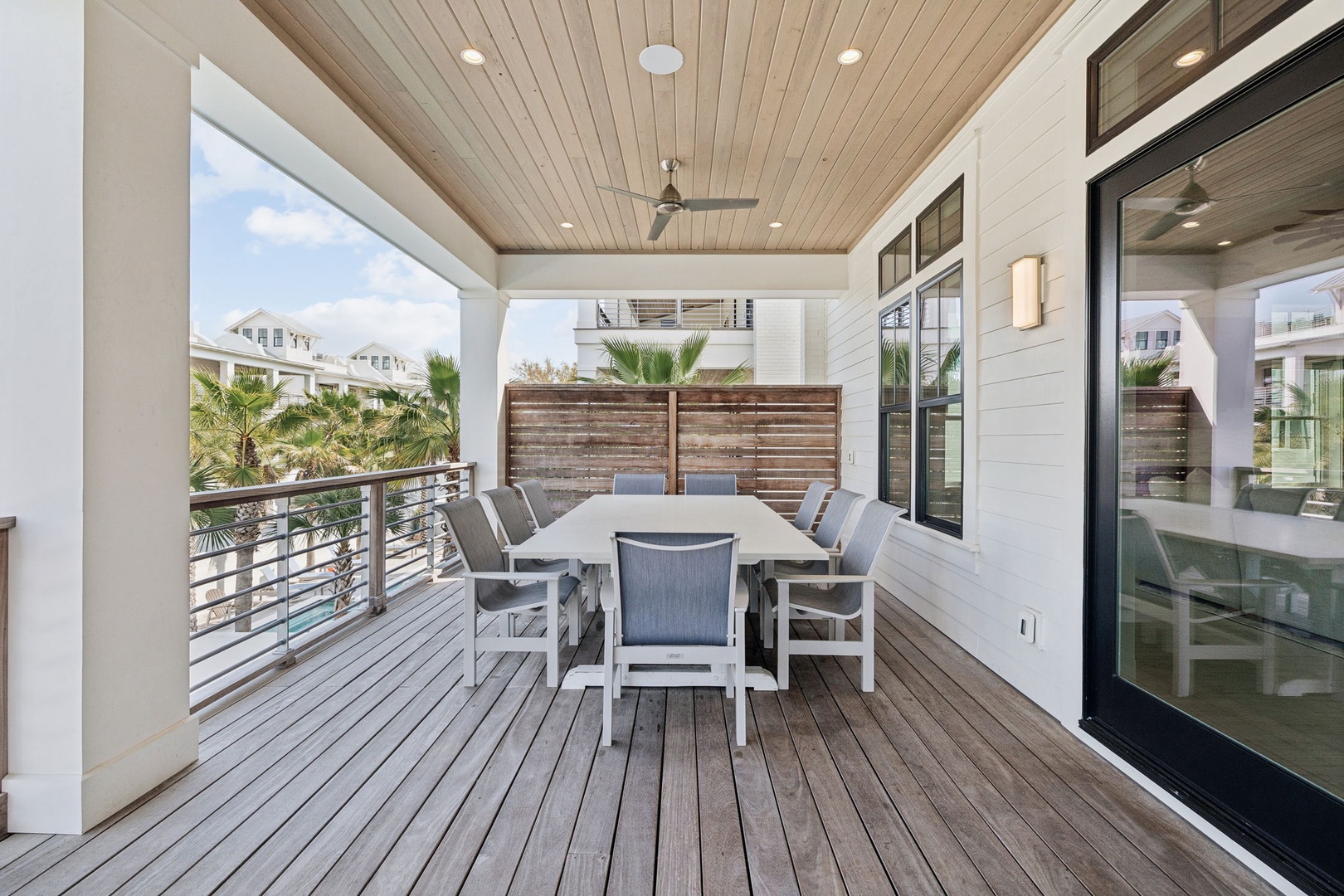 Your private covered terrace offers seamless indoor-outdoor living with elegant dining space, ceiling fan comfort, and tropical views.