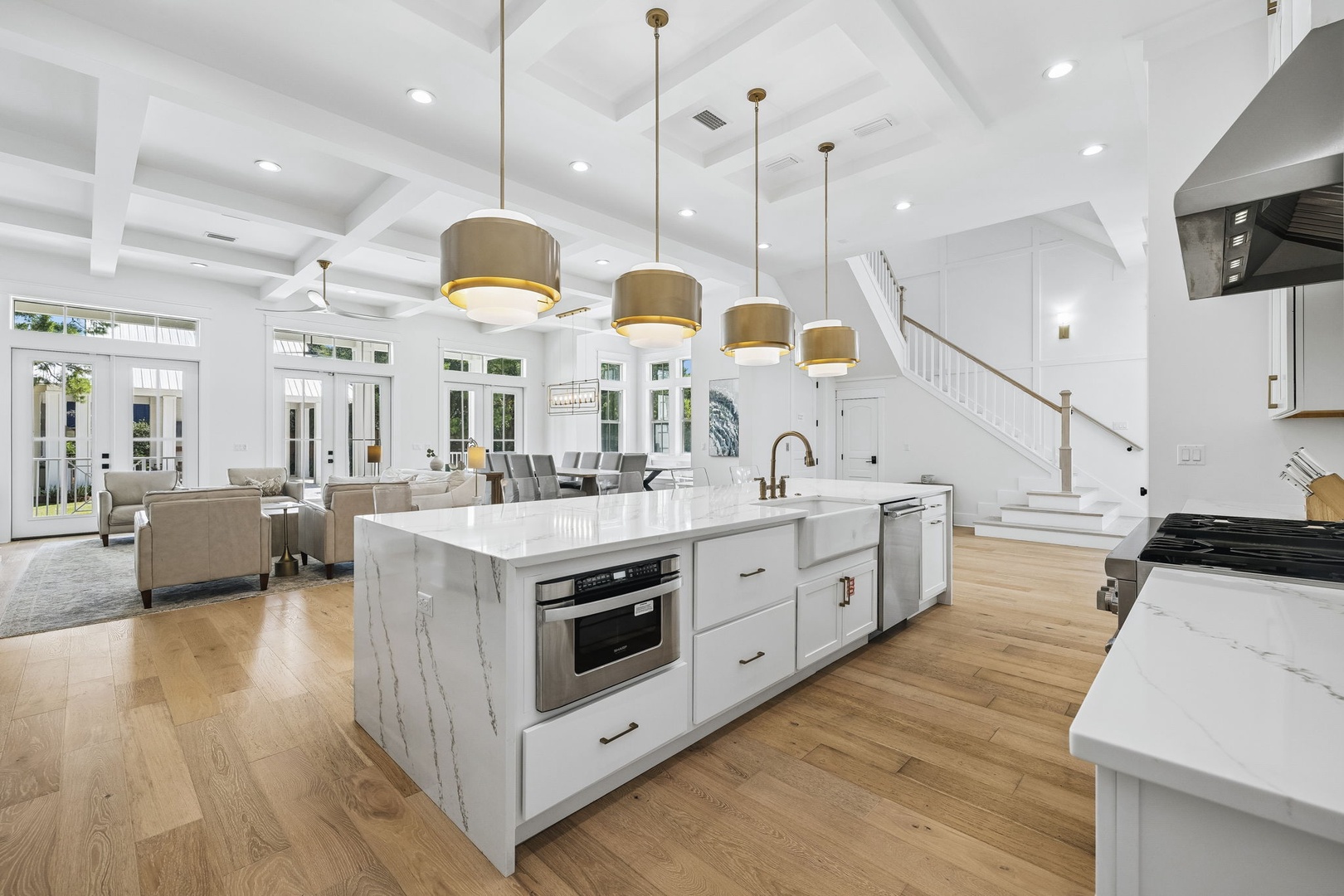 Step into this airy, light-filled space where the kitchen seamlessly flows into the living and dining areas. Cook in style beneath designer pendant lighting, then gather your group around the generous island or relax in the sunlit lounge beyond.
