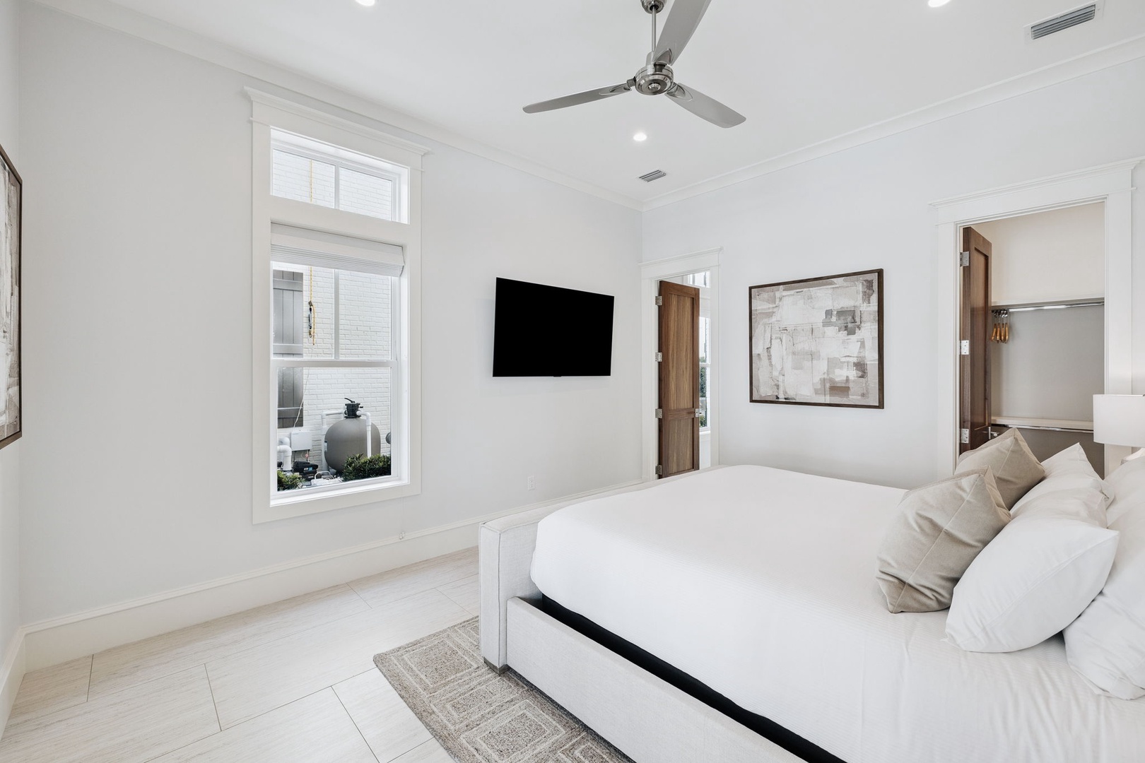 Drift off in this serene bedroom where white linens meet modern comfort. Your private TV and gentle ceiling fan create the perfect retreat.