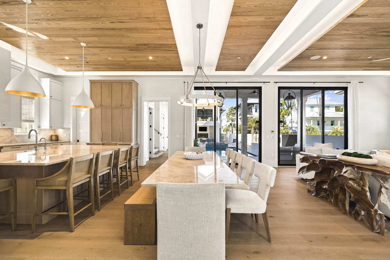 You'll love gathering in this stunning open-concept space, where warm wood tones and soaring ceilings create an airy, modern coastal retreat. The gourmet kitchen flows seamlessly into your dining area, perfect for memorable meals together.