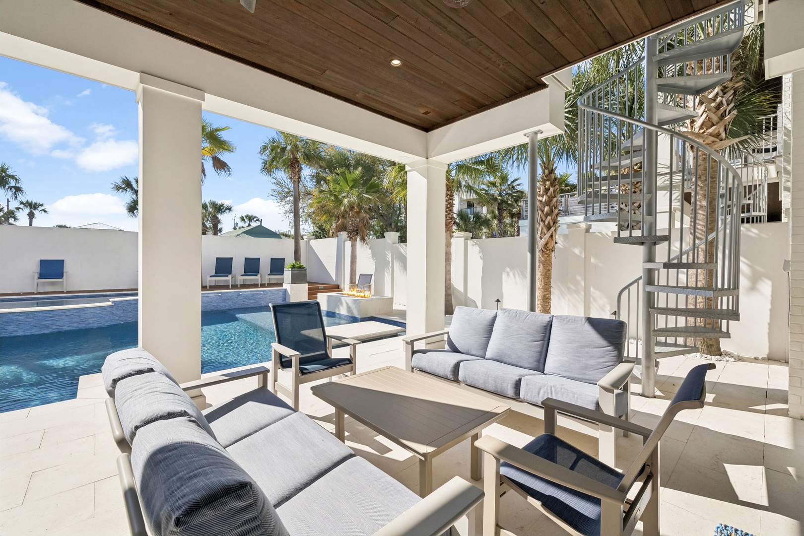 Relax in your private poolside retreat, where comfortable seating and tropical palms create the perfect escape.