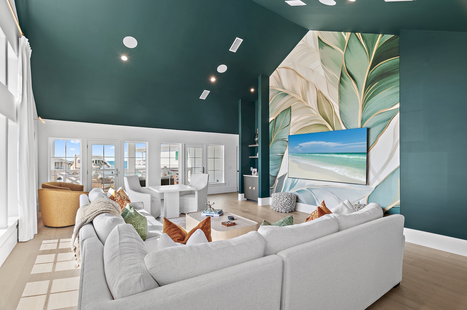 Sink into plush seating in this stunning coastal living room, where tropical artwork and ocean-view windows create your perfect beach escape.