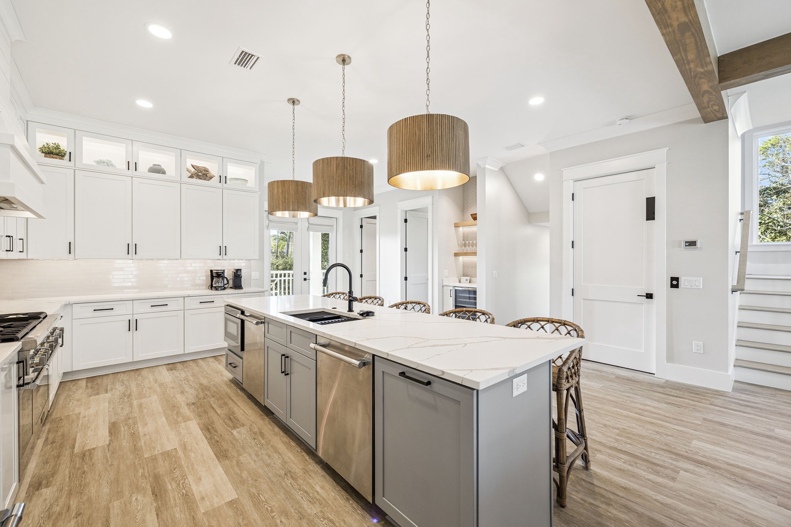Gather around this stunning kitchen island where warm pendant lights create the perfect ambiance for your morning coffee or evening conversations together.